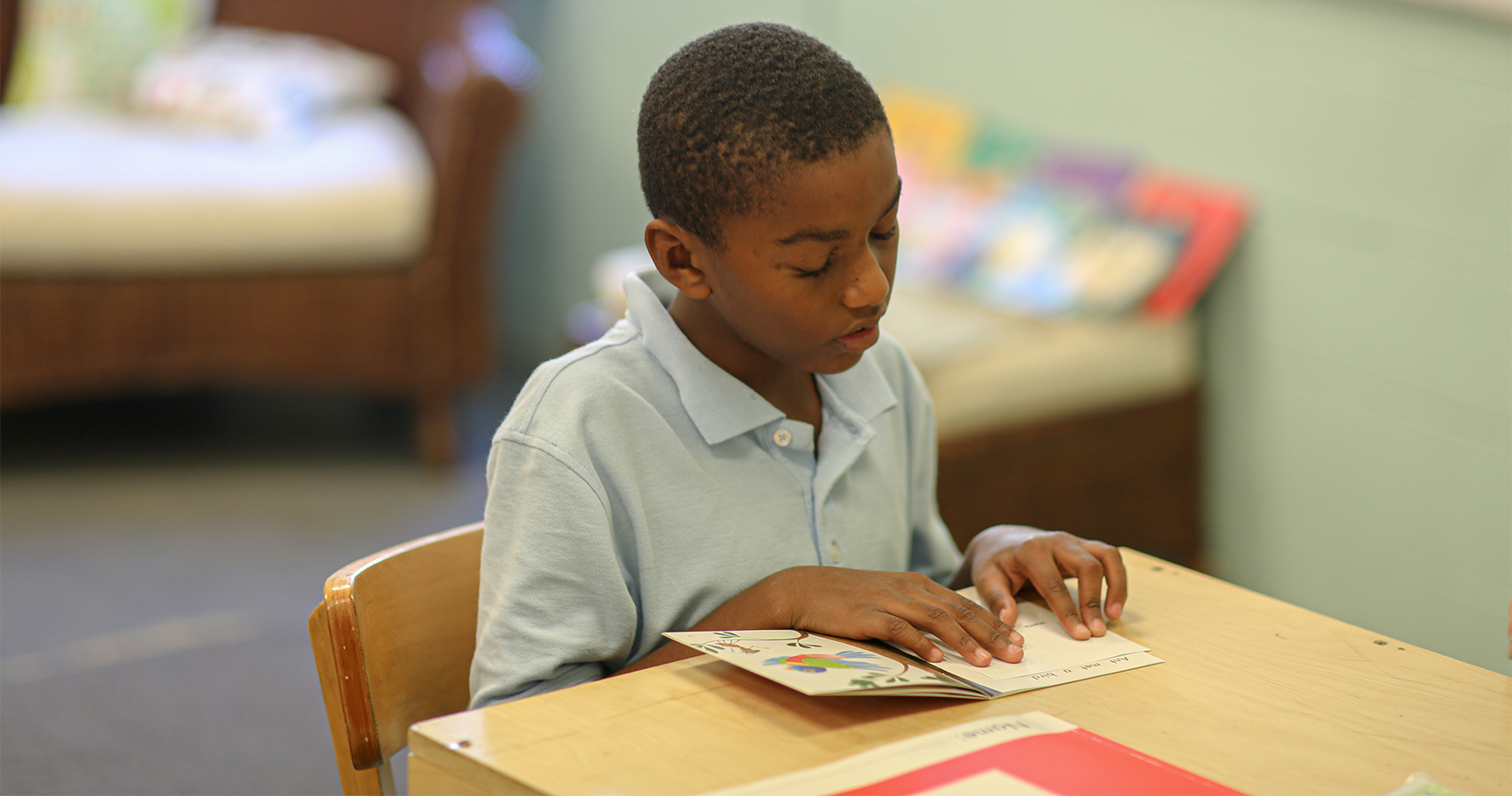 Raphael Academy student reads at his desk