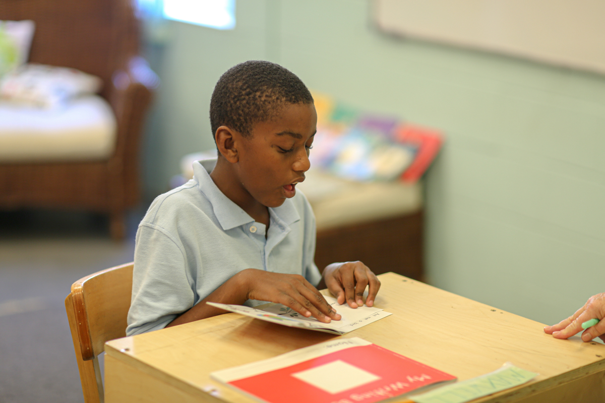 Raphael Academy student reads aloud at his desk