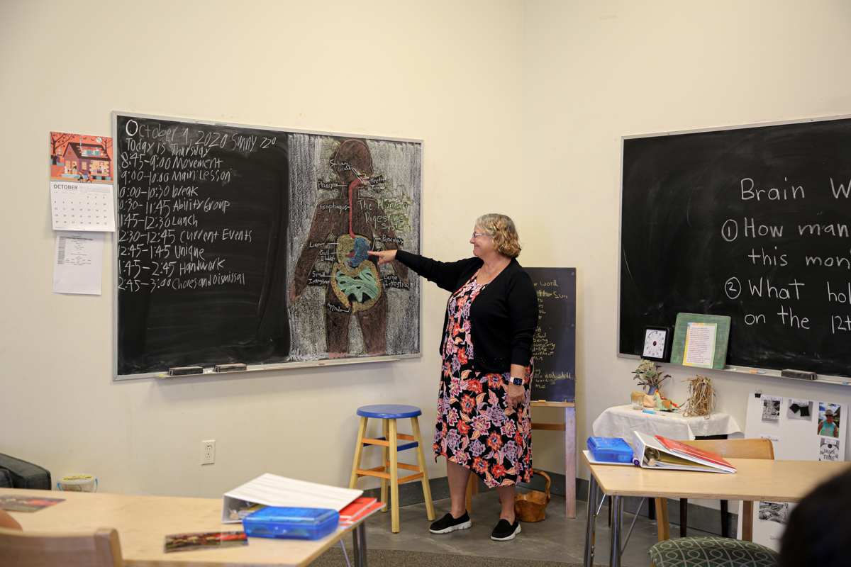 Raphael Academy teacher points at the chalkboard
