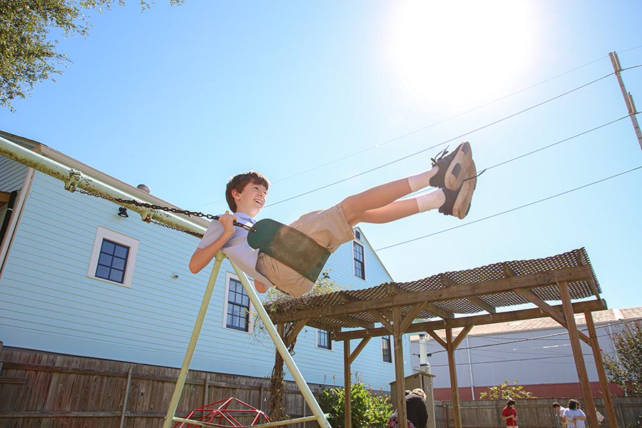 Raphael Academy student swings on the playground